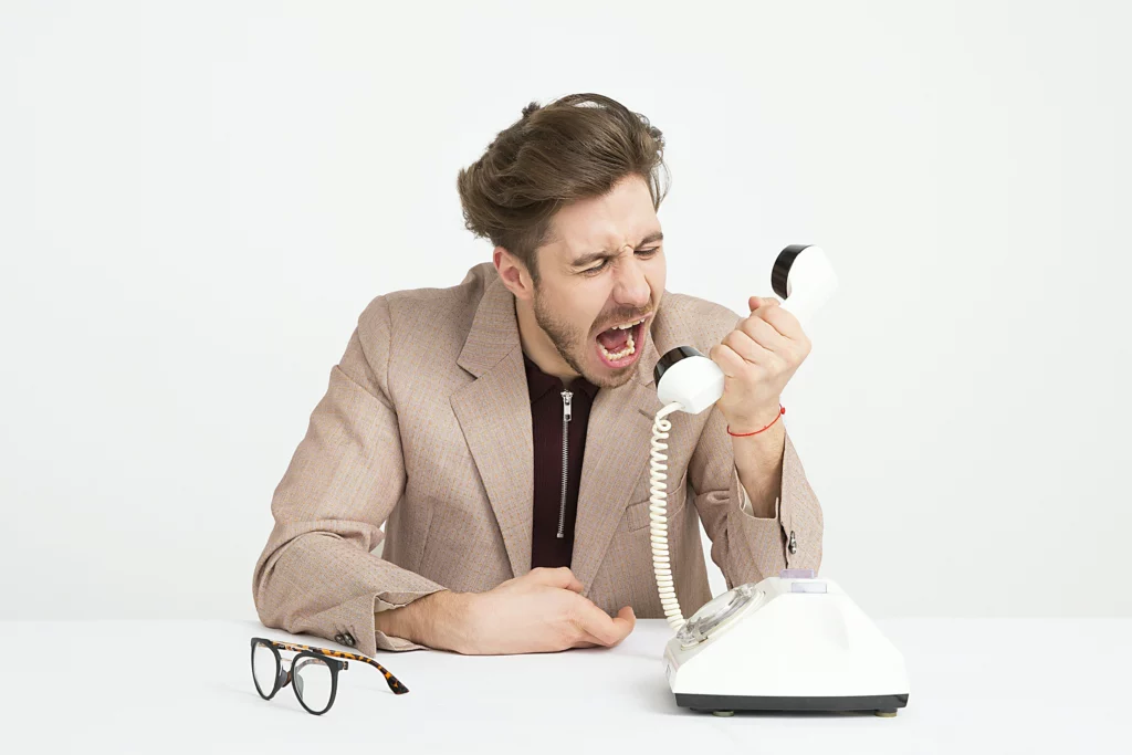A frustrated man wondering how to handle angry customers on the phone